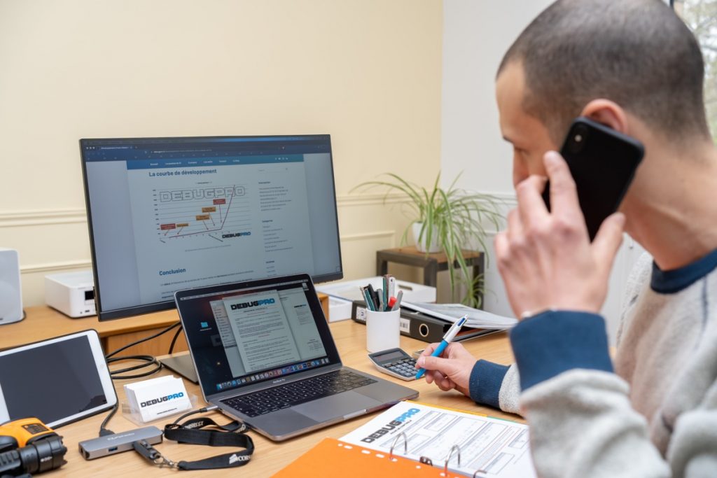 Gérant de DebugPro au téléphone, en train de réaliser un suivi professionnel des clients, illustrant l'engagement de l'entreprise envers un service client de qualité
